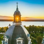 The photograph of the calm sunset viewed from the main dome tower of Pažaislis Monastery with the background of Kaunas Reservoir - artificial lake.